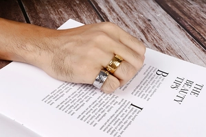 Detail showing the hammered texture on wide stainless steel rings in gold and silver