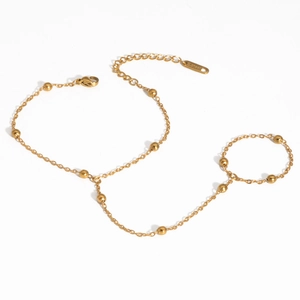 Détail d'un bracelet de doigt doré en acier inoxydable avec perles et fermoir mousqueton