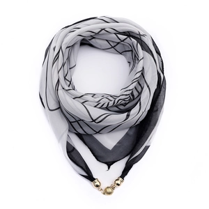 Detail of grey chiffon scarf featuring magnetic gold bead clasp and geometric patterns