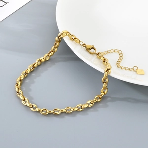 Close-up of 18K gold plated stainless steel anklet with pig nose chain on ceramic plate