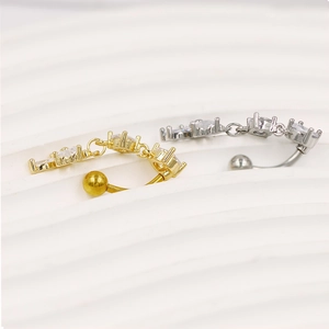 Détails de piercings de nombril or et argent avec pendentifs à trois pierres précieuses