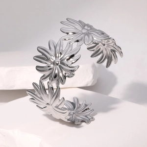 Macro shot of silver daisy flower design on stainless steel open cuff bracelet