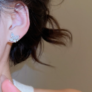Close-up of elegant cubic zirconia butterfly stud earring worn on the earlobe