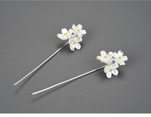 Macro shot of S925 silver forget-me-not drop earrings with yellow center floral detail