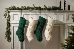 Close-up of four knitted Christmas stockings hanging on a vintage wooden fireplace