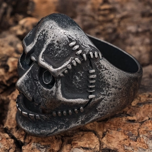 Macro di anello con teschio retrò in argento su sfondo di legno rustico