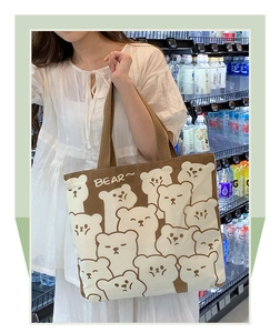 Detailed side view of canvas tote bag with cartoon bear print and beige-brown patchwork