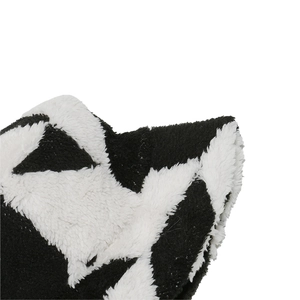 Détail macro de la texture en fausse fourrure avec motif étoile noir et blanc sur le chapeau