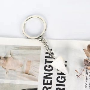 Detail view of hexagonal white crystal stone pendant keychain on a minimalist metal ring