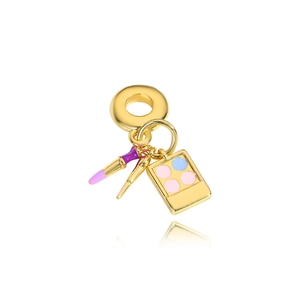 Macro detail of a gold lipstick and eyeshadow charm with purple and pink enamel finish