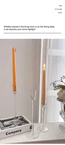 Close-up of elegant clear glass tall candle holder with slender orange candle for home decor