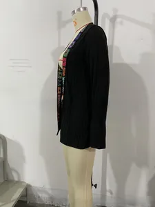 Close-up of colorful crochet floral embroidery on a black ribbed knit cardigan