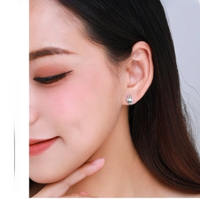 Macro shot of silver palm stud earring worn on ear with fashion jewelry text
