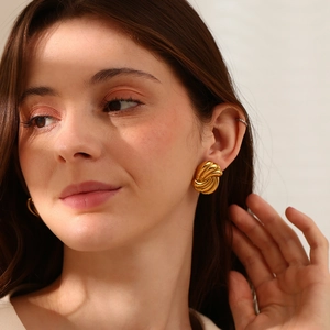 Élégantes boucles d'oreilles nœud en acier inoxydable plaqué or 18 carats sur modèle