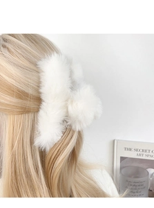 Close-up of white plush hair claw clip made of soft faux fur for thick hair styling