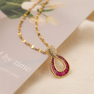 Detailed close-up of a gold waterdrop pendant with pink zircon and micro-pave stones