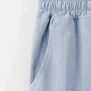 Dettaglio dei pantaloni da spiaggia in lino con vita elastica e sottili strisce