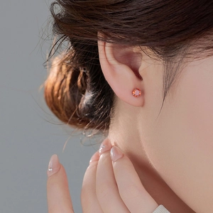 S999 silver stud earrings with round amber-colored gemstones worn by a model