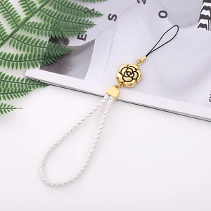 Detail of white woven leather phone strap with golden camellia charm and black cord end