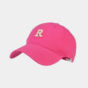 Macro di cappellino in tela rosa con toppa ricamata della lettera R in bianco avorio