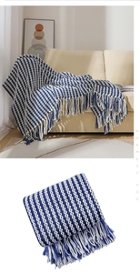 Detail showing blue and white striped knit texture and fringe on chenille blanket