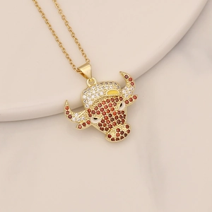 Detail of a golden bull head necklace pendant with red and white inlaid crystals