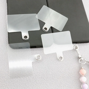 Close-up of four translucent phone tether tabs with reinforced silver metal rings on a phone