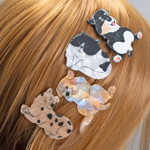Mollette per capelli a forma di cane in acetato colorato su lunghi capelli biondi