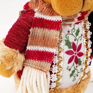 Macro shot of knitted scarf texture and floral embroidery on Christmas doll decor