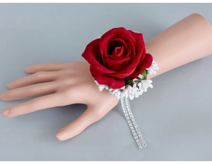 Detail of red velvet rose wrist corsage with rhinestone band for weddings and proms