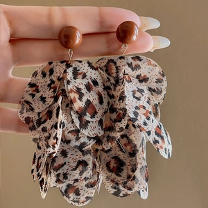 Macro detail of leopard print fabric layers on stylish vintage hoop drop earrings
