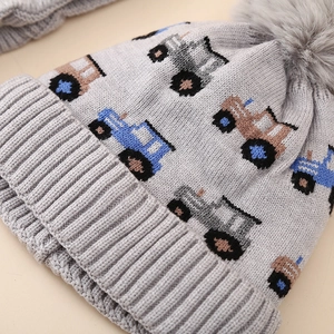 Detail of grey winter knit hat for kids featuring blue jacquard tractor patterns and pompom