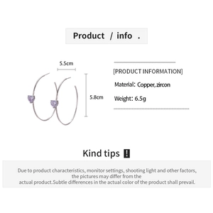 Detailed view of silver hoop earrings featuring light purple heart-shaped zircons