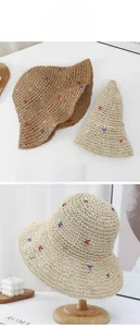 Detail of hand-woven straw hats with colorful star embroidery and wide brim for sun protection