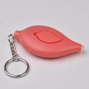 Macro shot of leaf-shaped personal alarm in coral orange with a silver keychain and LED light