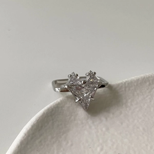Detail of a geometric 925 silver ring featuring a clear triangle-cut zircon heart