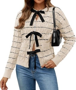 Detail of beige knit cardigan featuring black bow tie closures and fine striped texture