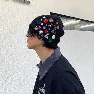 Détail de boutons colorés sur un bonnet en maille noire avec protection des oreilles