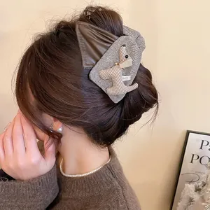 Brown leather and houndstooth puppy hair claw clip shown on model from back view
