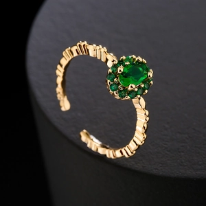 18K gold plated ring with emerald green stone and zircon pavé on a black pedestal