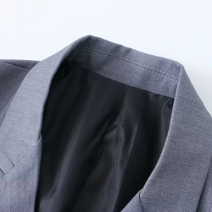 Détail du revers gris montrant le tissu sergé de qualité et les coutures du blazer