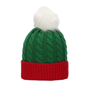 Detail of red and green cable knit Christmas hat with a fluffy white pom-pom