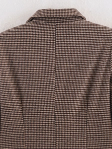 Detailed view of the brown houndstooth pattern and thick wool fabric on the coat back