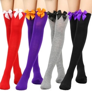 Detail of Christmas over-knee socks in four colorways featuring silk bow accents