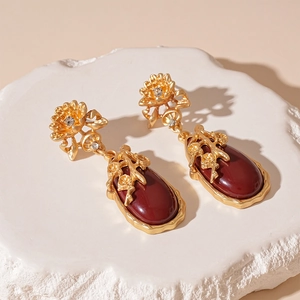Détail macro de boucles d'oreilles vintage en or avec une grande pierre rouge en goutte