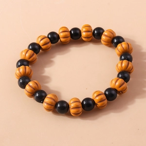 Close-up of Halloween beaded bracelet featuring black rounds and orange pumpkin charms