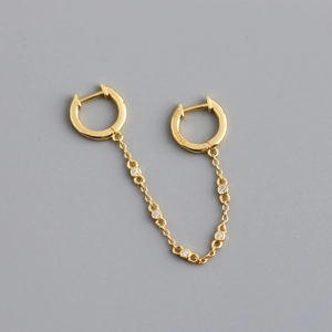 Detailed macro view of S925 sterling silver stamp on golden double hoop chain earrings