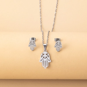 Detailed close-up of silver hollow Hamsa Hand necklace and stud earrings jewelry set
