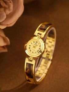 Elegant gold quartz bracelet watch with amber tortoise shell band and Roman numeral dial
