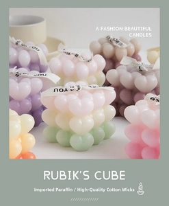 Close-up of pastel macaron bubble candles with decorative ribbons and heart shape